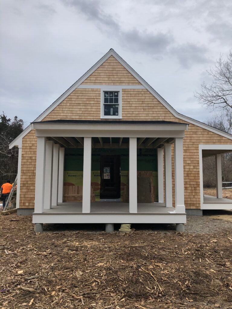 Renovate vs rebuild on Cape Cod — a custom home rebuild under construction with fresh cedar shingles