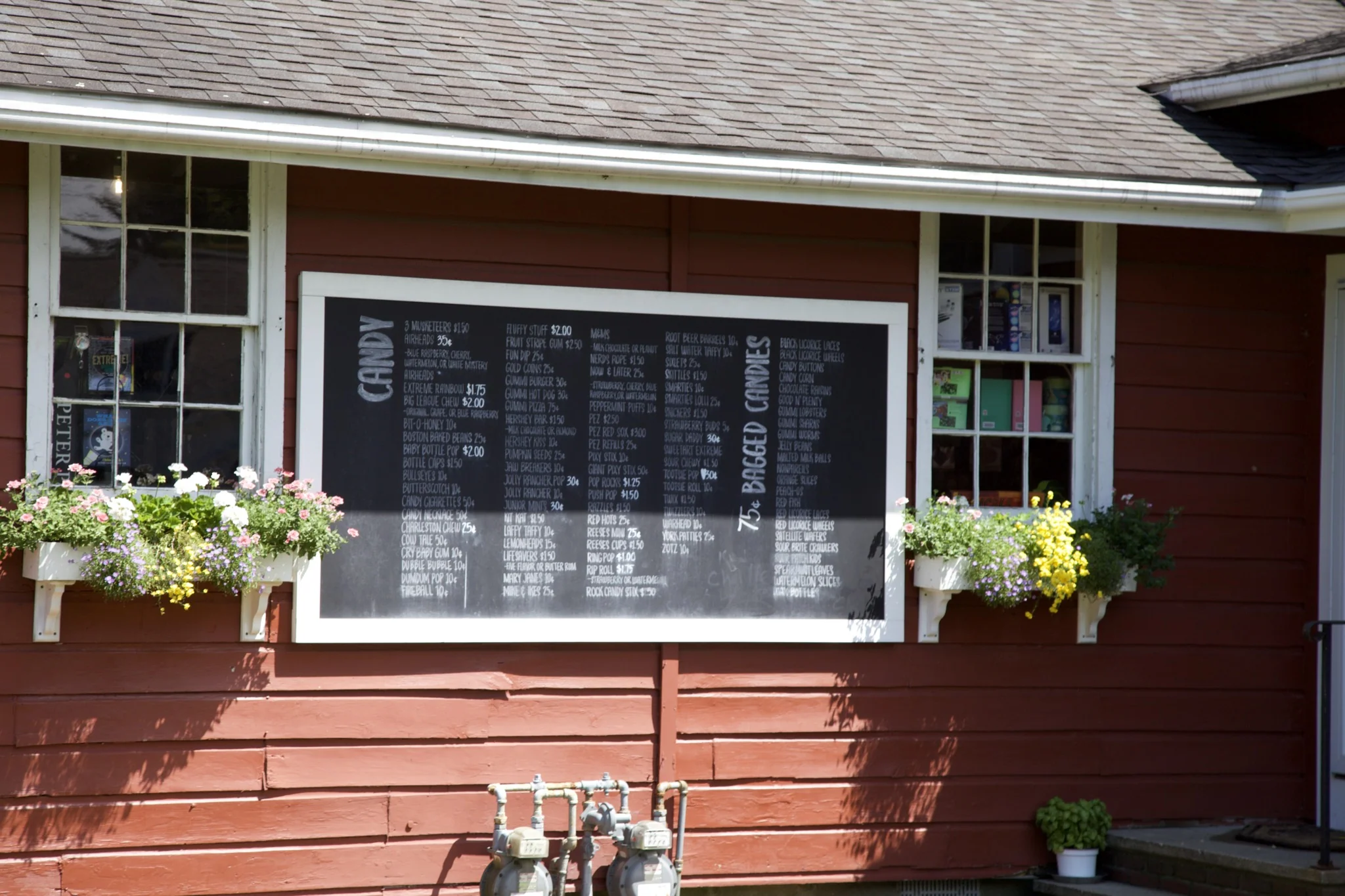 Hand-lettered candy board on the red clapboard wall of the 1856 Country Store, Centerville