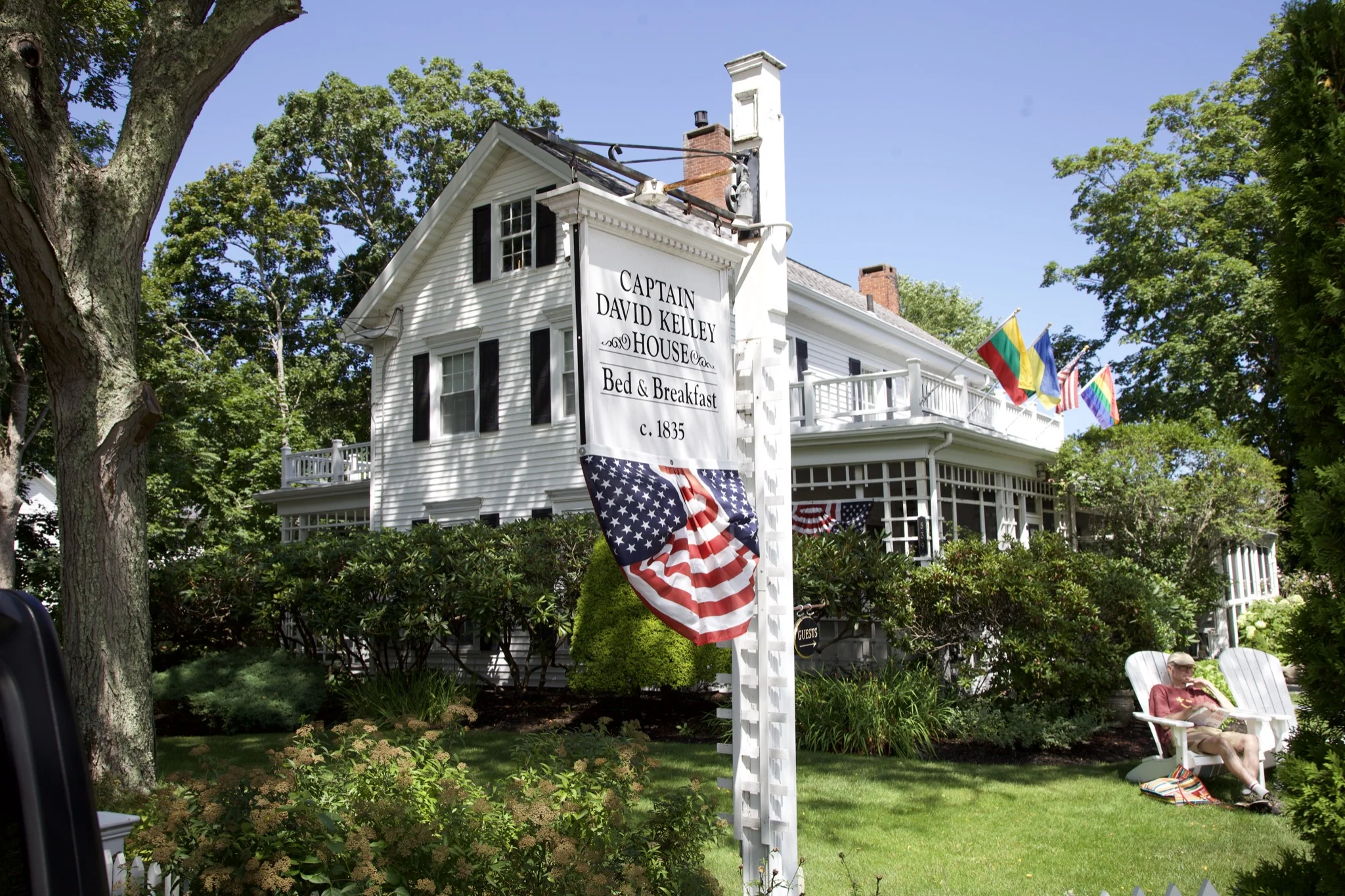 Historic Centerville inn with wraparound porch and flag, Barnstable, Massachusetts