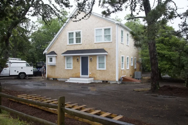 Newly built Cape Cod home with fresh cedar shingle siding, a gambrel roof, and white trim on a West Dennis lot