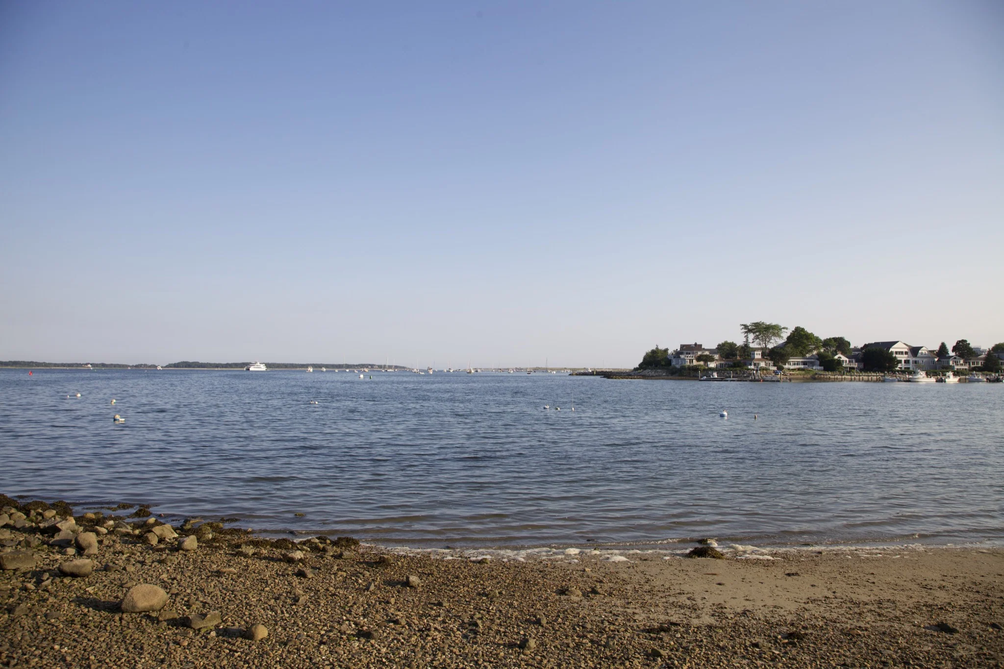Calm inner harbor water and distant shoreline homes at Hyannis Port