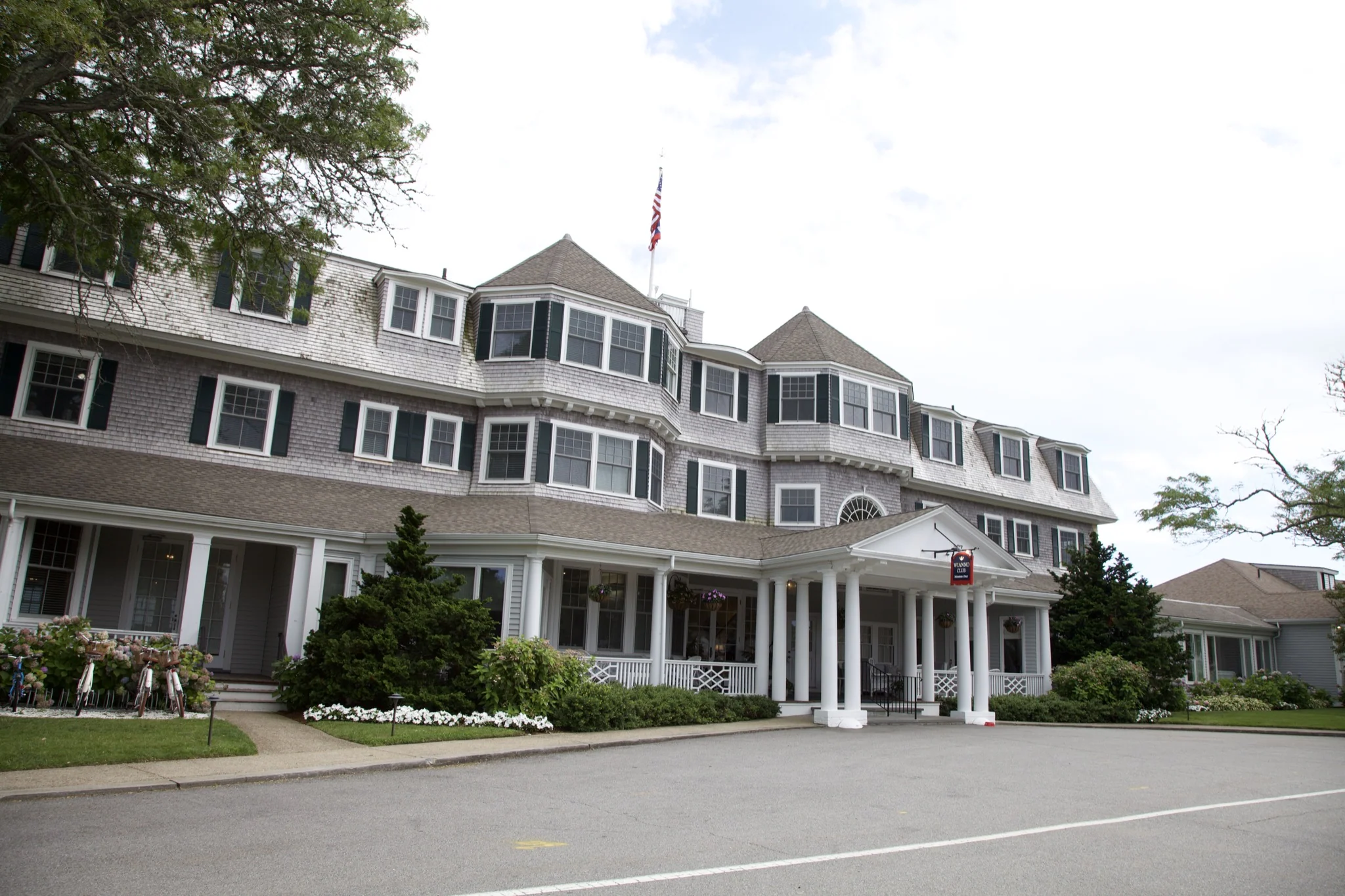 Large shingle-style building with dormers and columned entry in Osterville, Barnstable