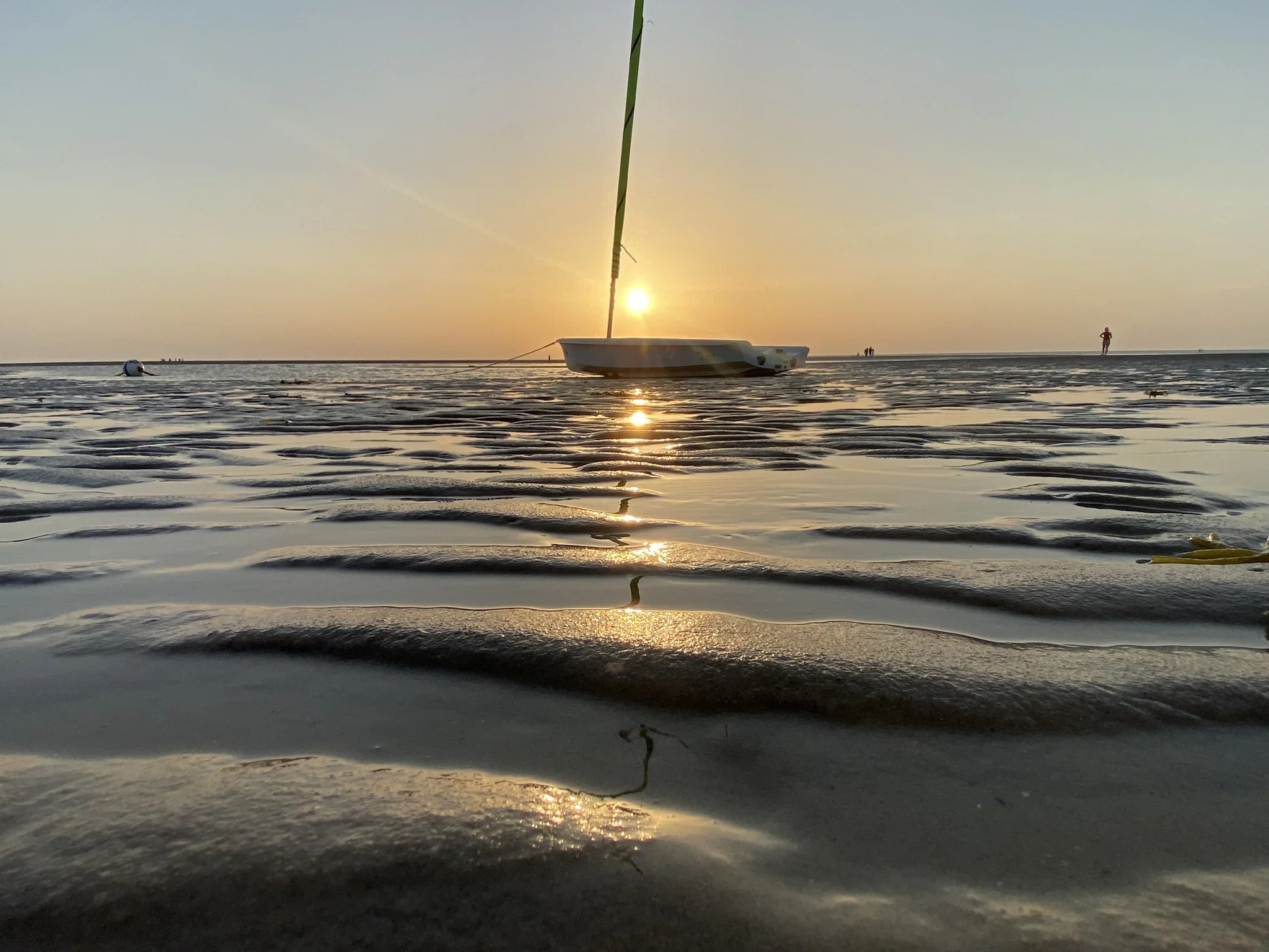 Sailboat resting on the exposed sand flats at sunset in Brewster, Massachusetts