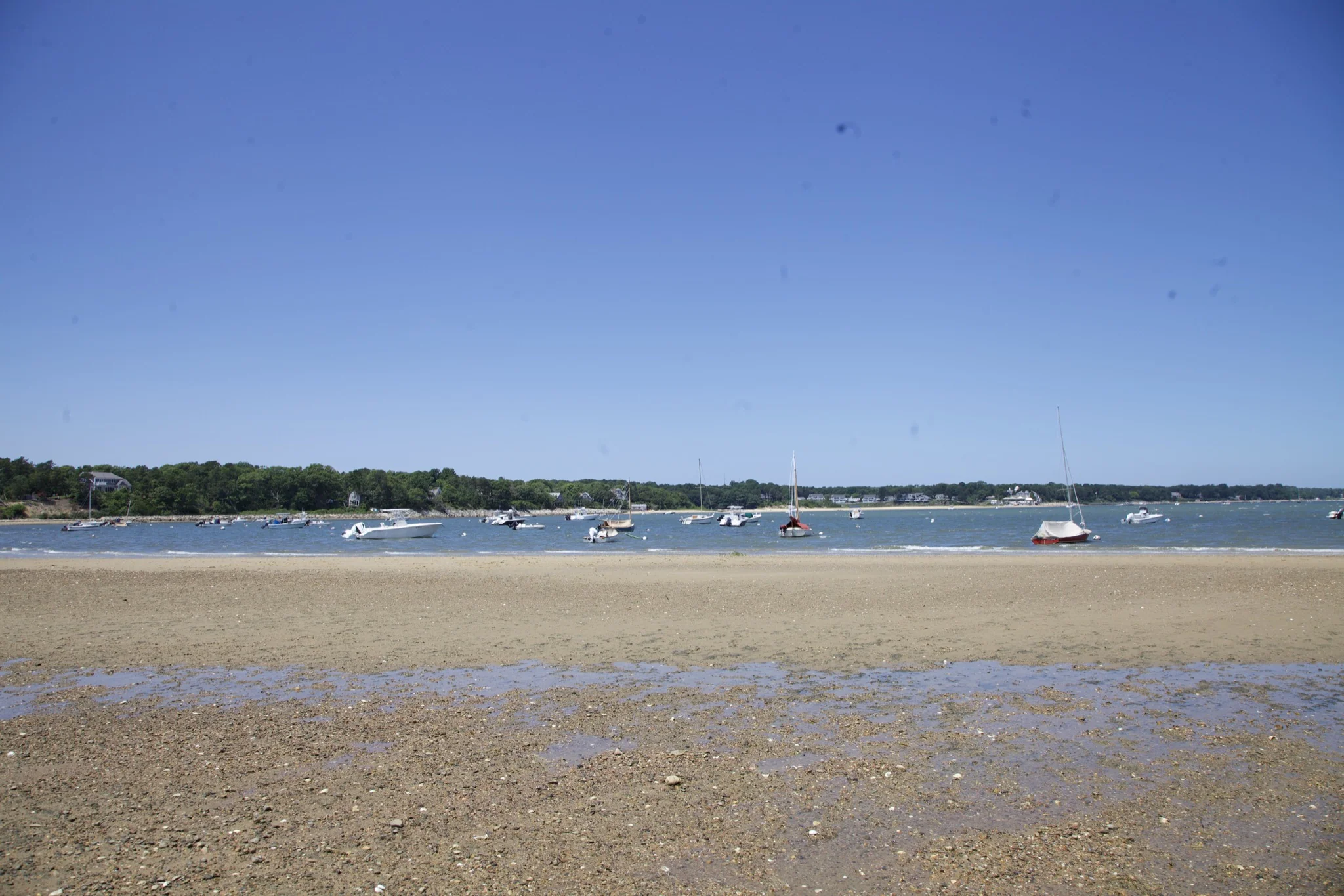 Boats moored in the channel beyond the exposed flats at low tide in Chatham
