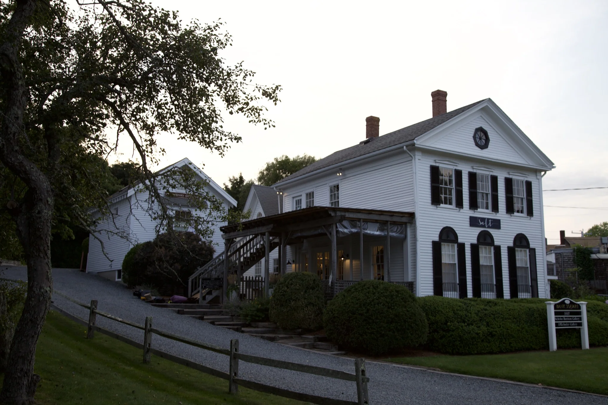 Historic white clapboard building with black shutters and a covered porch in Wellfleet